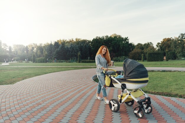 молодая мать наслаждается прогулкой в парке с ребенком