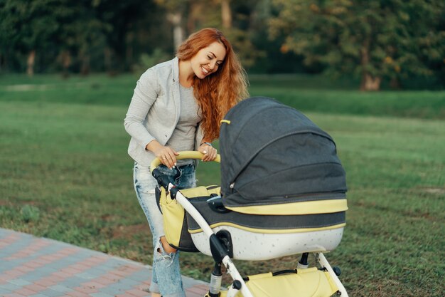 young mother enjoying walk in park with baby