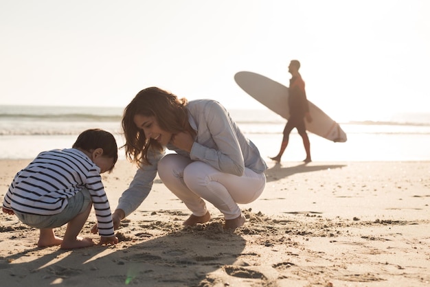 Giovane madre che esplora la spiaggia con il bambino