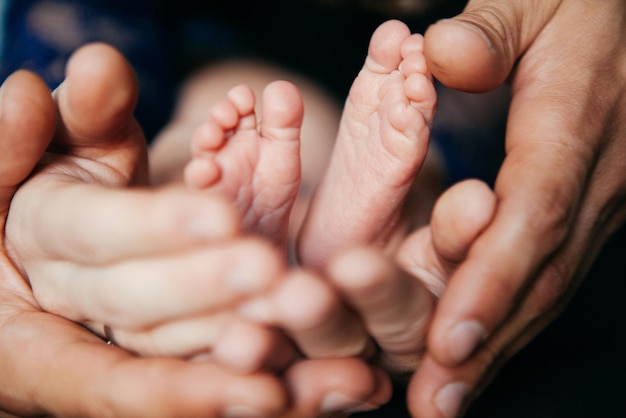 Young mother and father hold their newborn son in their arms