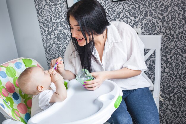 Giovane madre che alimenta il suo piccolo bambino