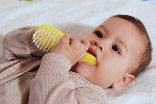 Young mother hand holding comb and brushing her baby Close up Mother care Concept of parenthood