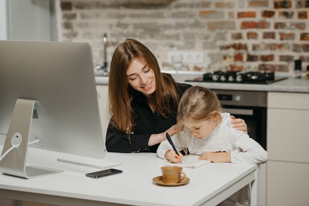 Young mother helping her daughter with homework