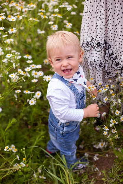 Young mother and her cute little son walking in a field