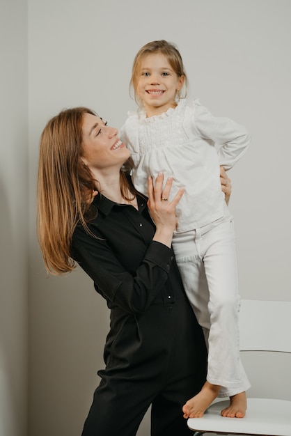 Young mother and her daughter on a tall chair