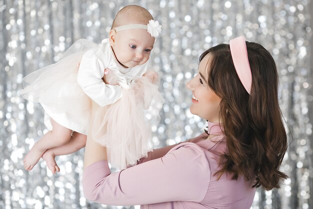 Young mother and her little baby daughter with christmas tree