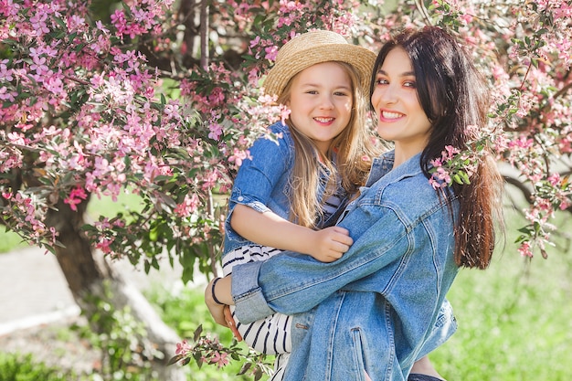 Young mother and her little daughter having fun together outdoors