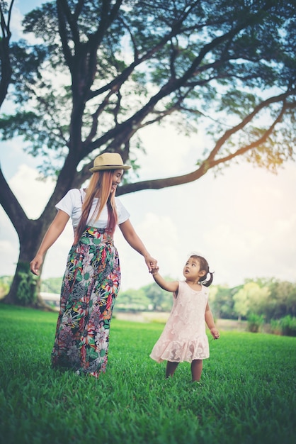 La giovane madre e la sua piccola figlia che camminano in ther parcheggiano