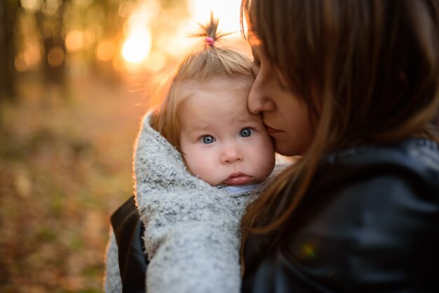 Young mother and her toddler girl in autumn fields