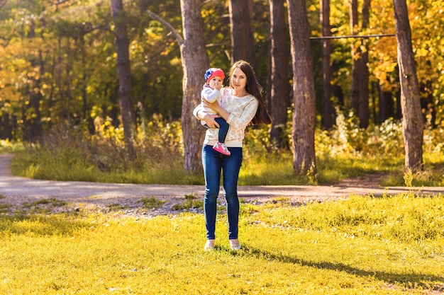 Young mother and her toddler girl have fun in autumn.