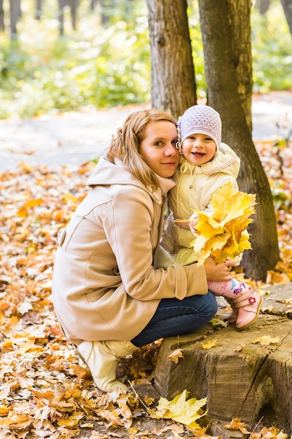 Young mother and her toddler girl have fun in autumn