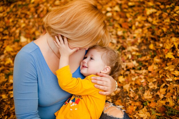 Foto la giovane madre e la sua ragazza del bambino si divertono in autunno