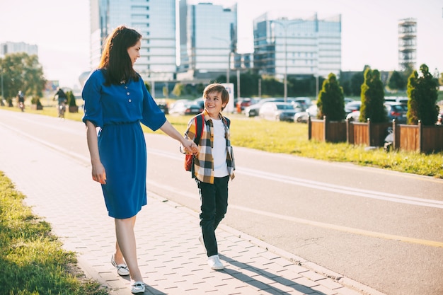 Young mother and his son on the way to school