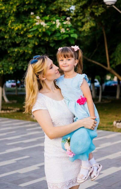 Photo a young mother holds her little daughter in her arms a strong loving hug