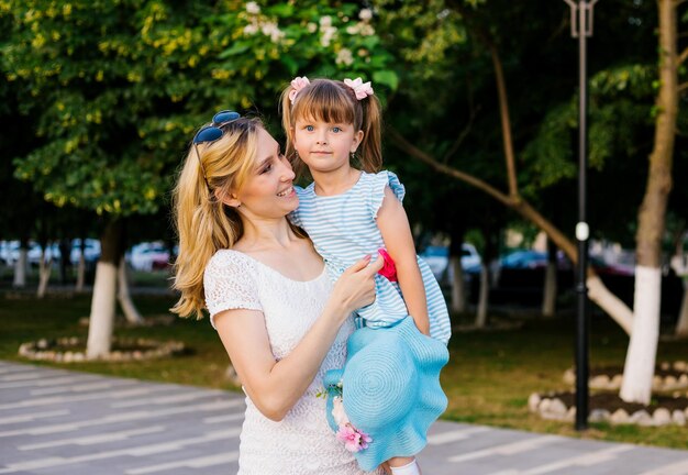 A young mother holds her little daughter in her arms A strong loving hug