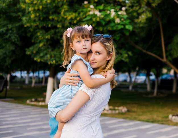 A young mother holds her little daughter in her arms A strong loving hug