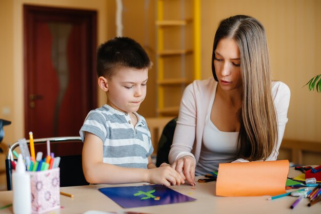 A young mother is doing homework with her son at home