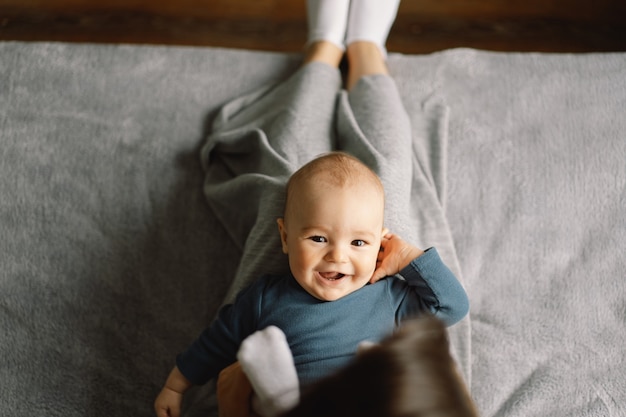 若い母親が小さな男の子と遊んでいます。授乳中の赤ちゃんの母親。幸せな母性。家族は家にいます。幸せな母と子のポートレート。