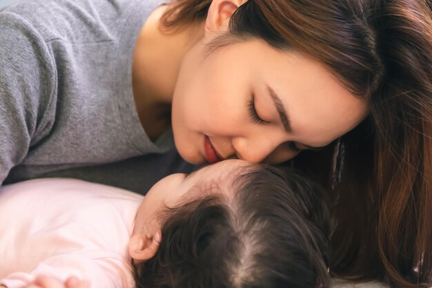 写真 若い母親が子供や娘にキスをする