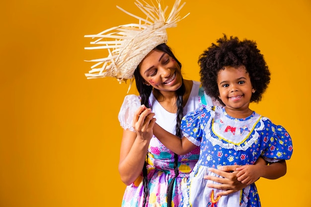 Young mother and little daughter dressed in festa junina outfit for the june party