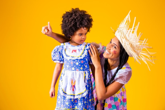 Young mother and little daughter dressed in festa junina outfit for the june party