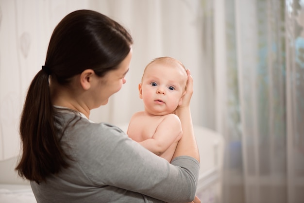 生まれたばかりの子供を授乳している若い母親