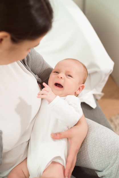 生まれたばかりの子供を授乳している若い母親