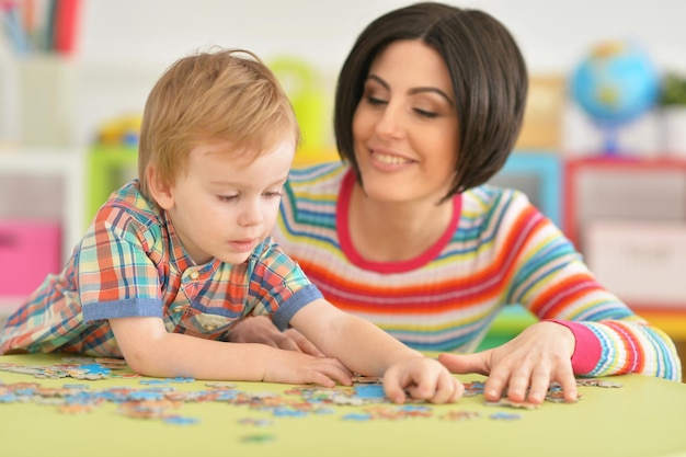 Young mother playing with cute little son