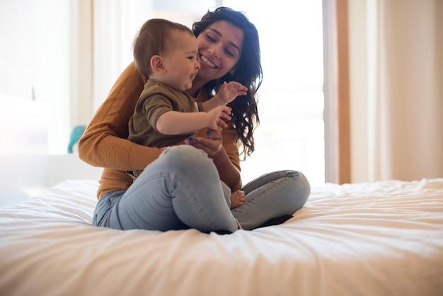 Young mother playing with her baby at home