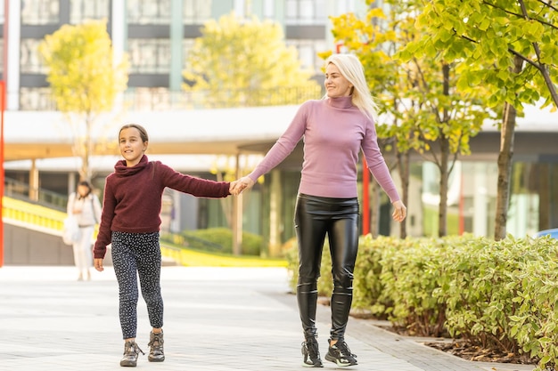 Giovane madre che gioca con sua figlia nel parco autunnale.