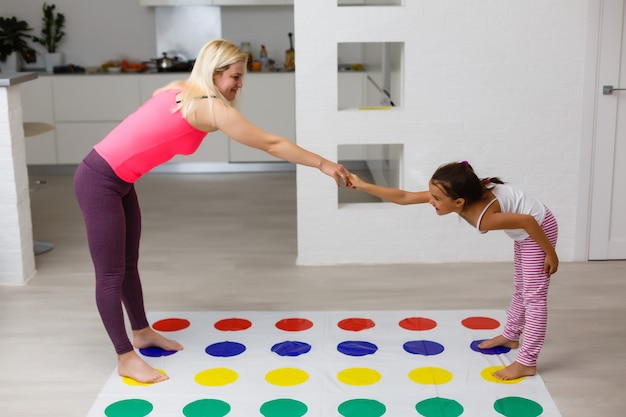 Young mother playing with her kids. Cheerful family at home. Happy family having a fun together.