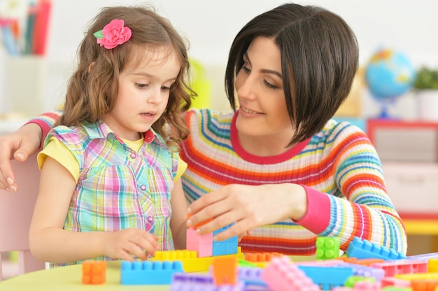 Young mother playing with little daughter