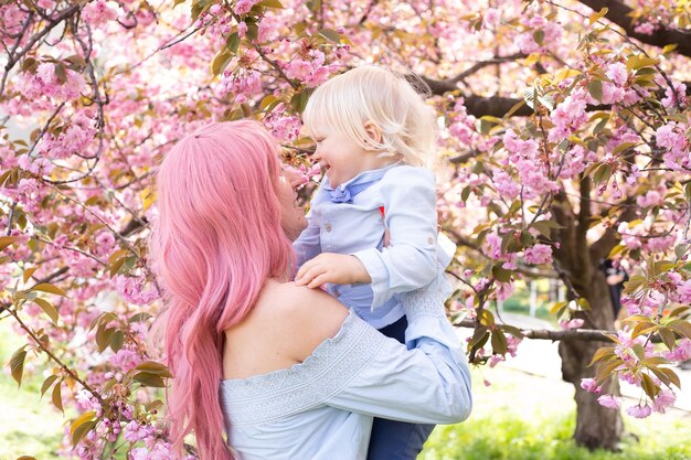 Young mother playing with a small son in the park in spring