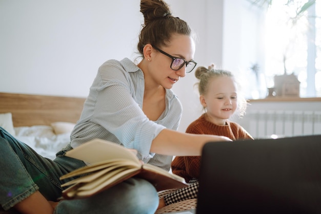 若い母親が電話で話し、子供の世話をしながら仕事の問題について話し合うCovid19