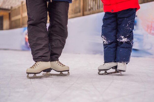 Photo young mother teaching her little son ice skating at outdoor skating rink family enjoy winter on icerink outdoors