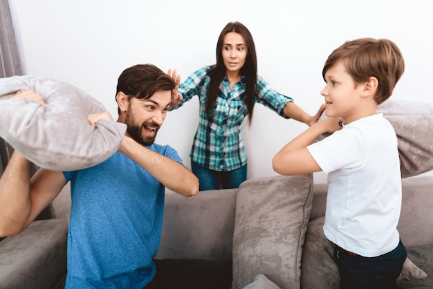 Young mother tries to calm adult husband and son.