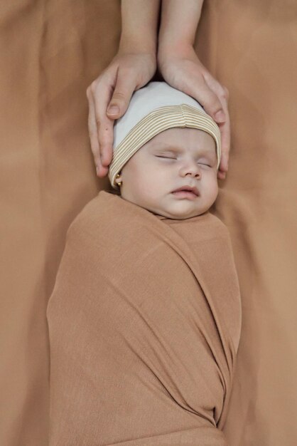Молодая мать носит головные уборы для маленьких девочек Материнство, милая семья, милая новорожденная девочка