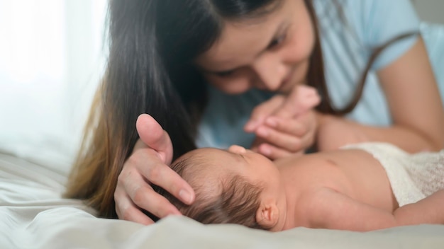 かわいい生まれたばかりの赤ちゃんを持つ若い母親