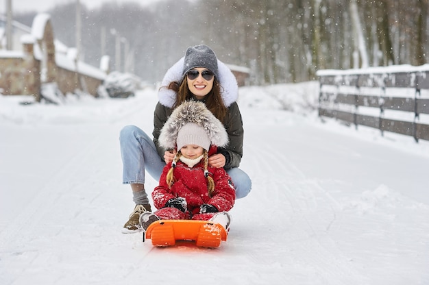 A young mother with her children having fun on wintertime