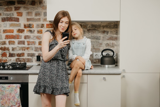 Young mother with her cute daughter in the kitchen