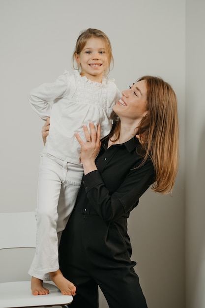 Young mother with her daughter on a chair