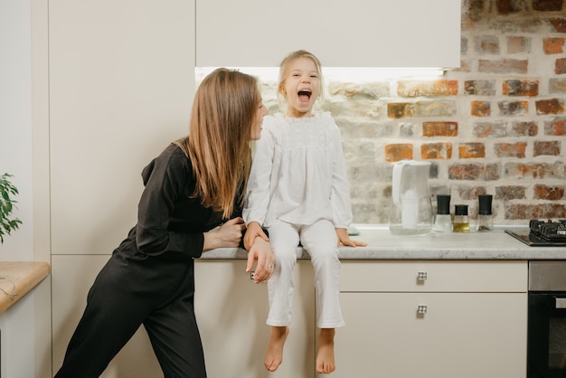 Young mother with her daughter in the kitchen