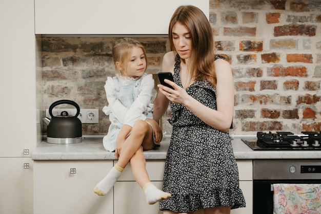 Young mother with her daughter in the kitchen