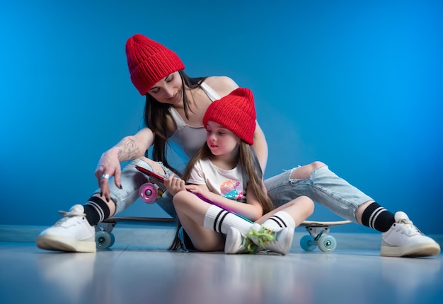 A young mother with her daughter on a skateboard and a longboard