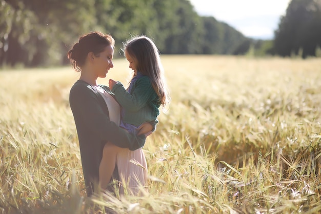 A young mother with her daughter on a walk in wheat fields