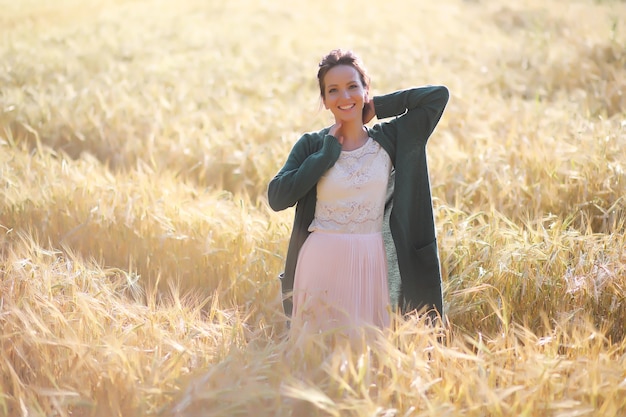 A young mother with her daughter on a walk in wheat fields