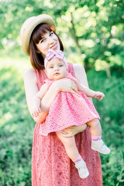 Young mother with her little baby on the meadow