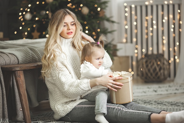 Young mother with her little daughter on christmas background