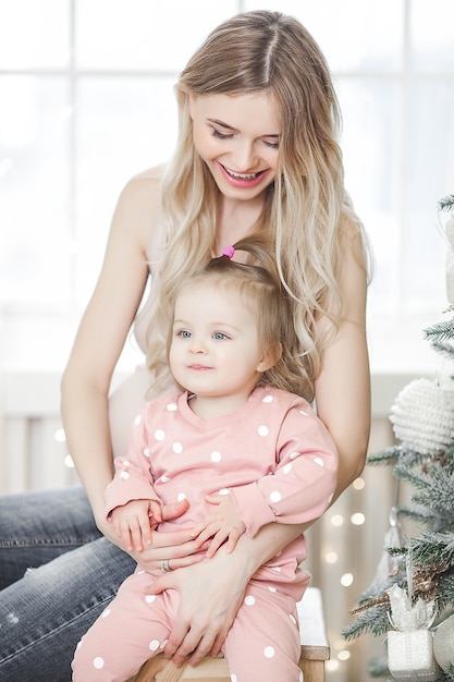 Young mother with her little daughter on christmas background