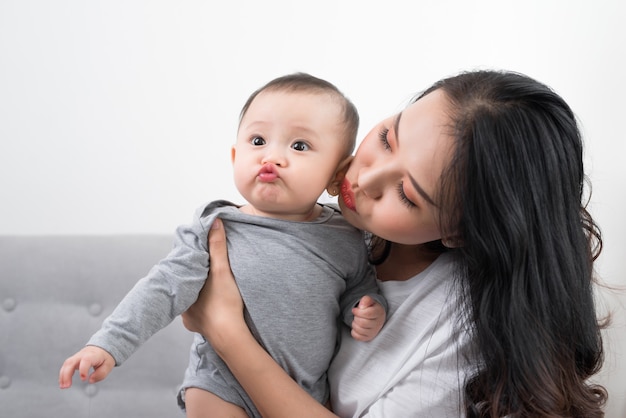 パジャマを着た1歳の幼い息子を連れた若い母親は、週末に一緒に居間で遊んだり、怠惰な朝を過ごしたり、暖かく居心地の良い場面でリラックスして遊んでいます.選択と集中。